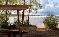 Serene lakeside scene featuring a wooden shelter, perfect for relaxation.