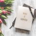 A notebook with 'Make It Happen' inscription beside a bouquet of pink tulips, capturing inspiration.